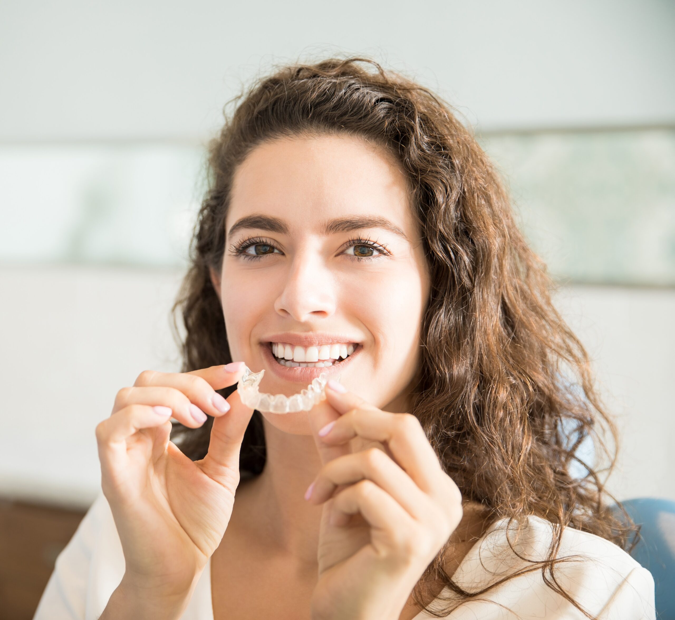 Beautiful Patient Holding Orthodontic Retainers In Dental Clinic